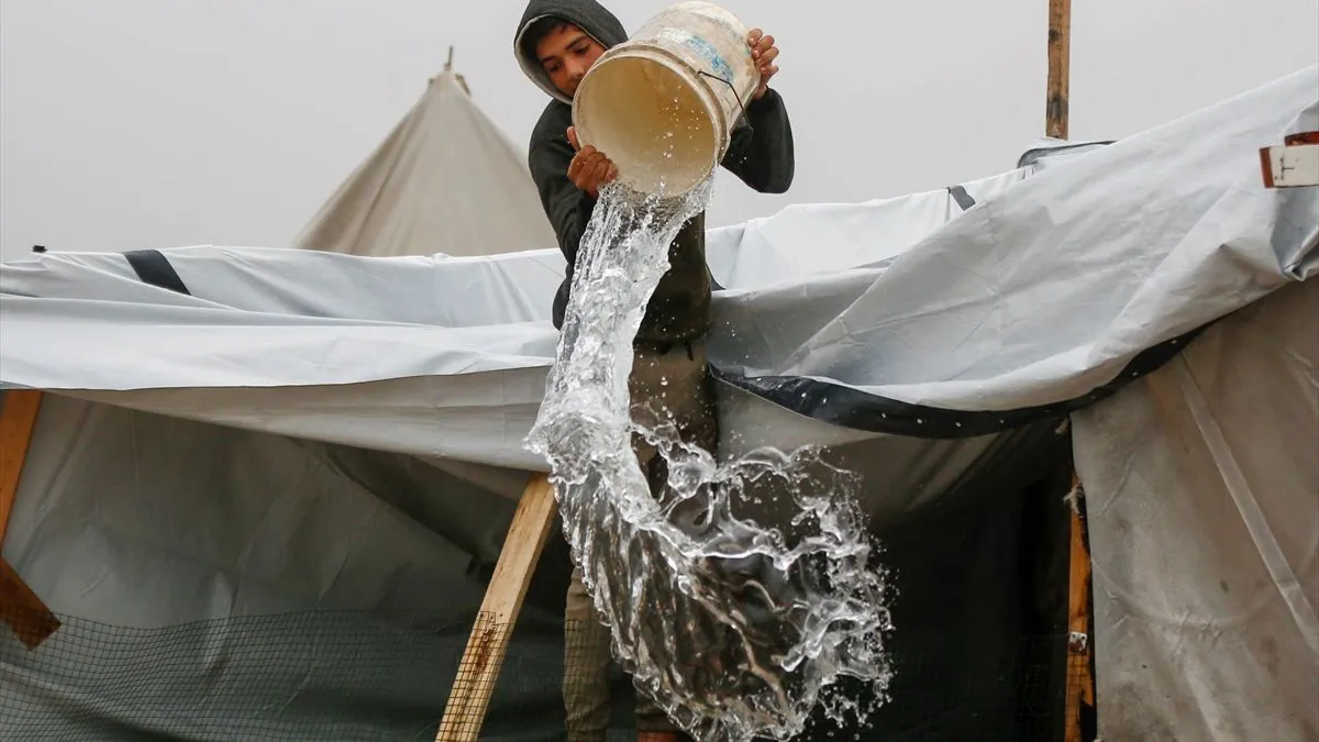 Dok se porodica okupljala oko male otvorene vatre na pješčanom nasipu pored šatora, Tawtah je izvlačio potpuno natopljen madrac kroz poplavnu vodu