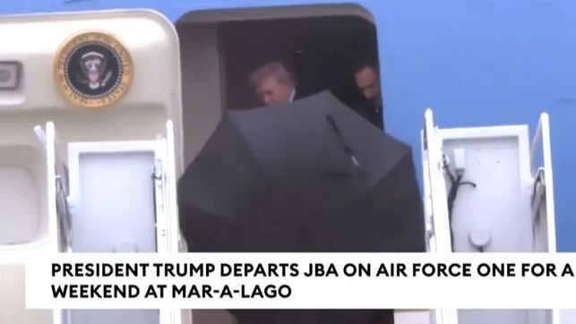 Boreći se s naletima i kišom, predsjednik SAD-a je držao veliki crni kišobran dok je išao uz stepenice aviona