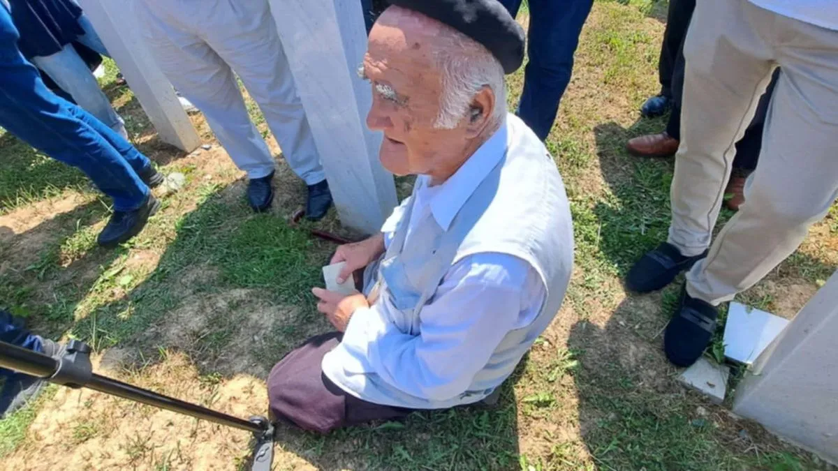 Vreli julski zrak treperio je iznad Šehidskog mezarja u Kamičanima, noseći sa sobom tihi jecaj i miris tek iskopane zemlje. 