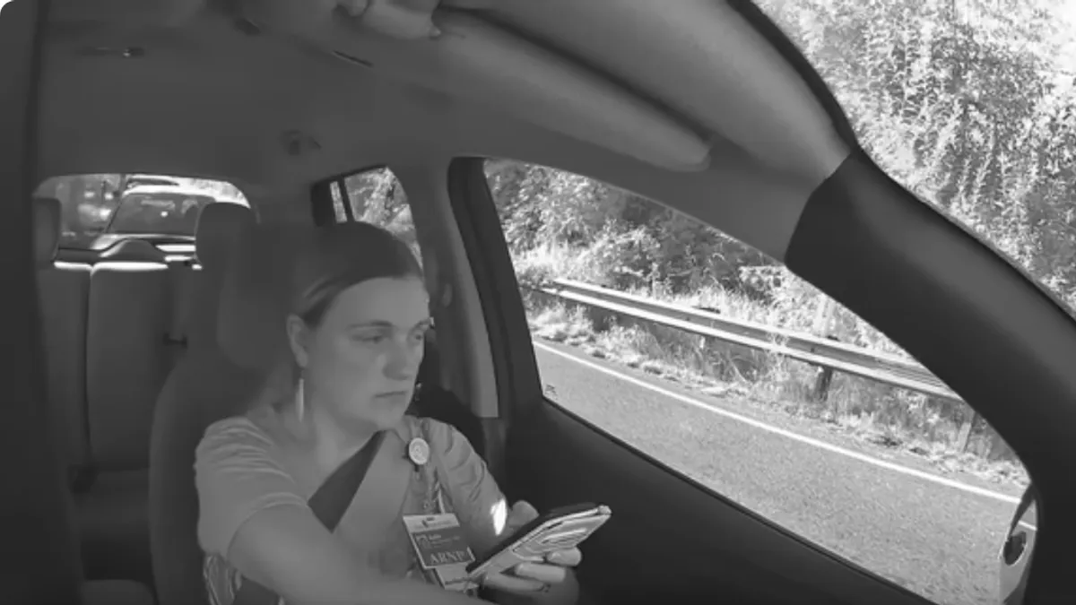 Dok se vozilo zaustavlja, žena stavlja glavu u ruke i bijesno jauče