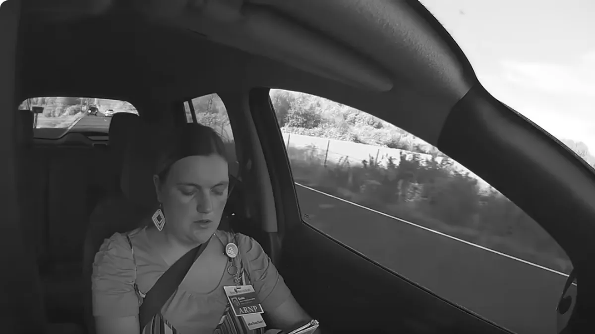 Dok se vozilo zaustavlja, žena stavlja glavu u ruke i bijesno jauče