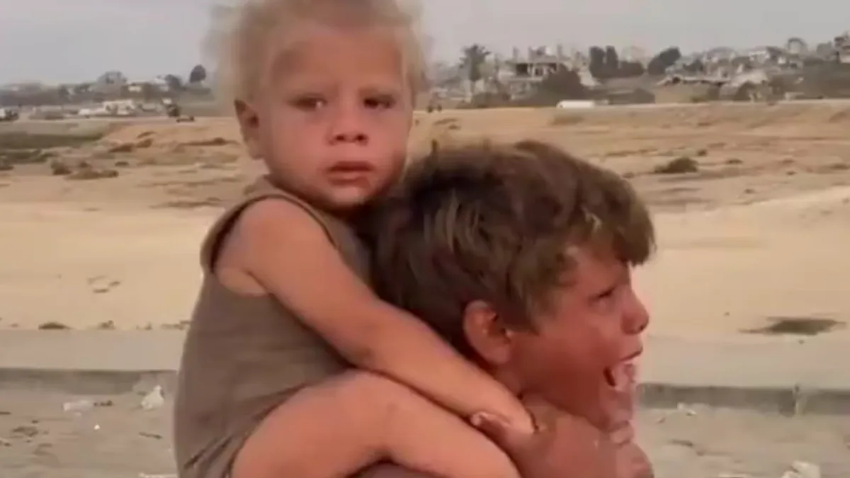 Na široko dijeljenoj fotografiji i snimku prikazan je Jadou, dječak od oko 10 godina, kako nosi mlađeg brata kroz ruševine i dim