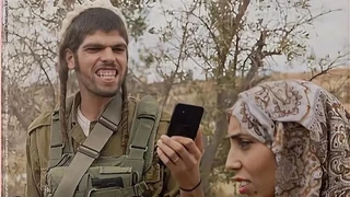 Fotografija prikazuje naoružanog izraelskog doseljenika kako snima Palestinku u teškoj situaciji.